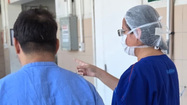 uma enfermeira e um homem caminham de costas